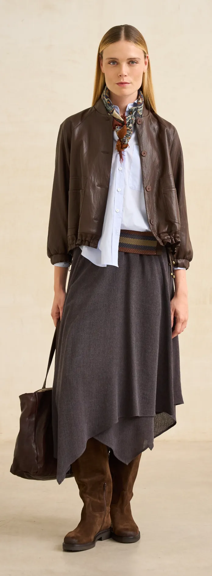 rivera realzamos tu figura 2 Chaqueta de piel marrón, camisa blanca y falda gris asimétrica de Rivera